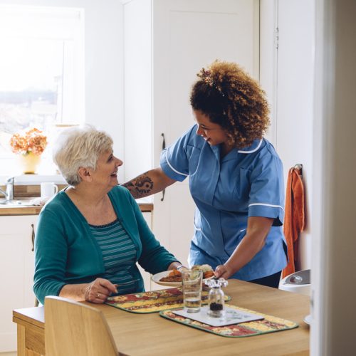 Care,Worker,Giving,An,Old,Lady,Her,Dinner,In,Her